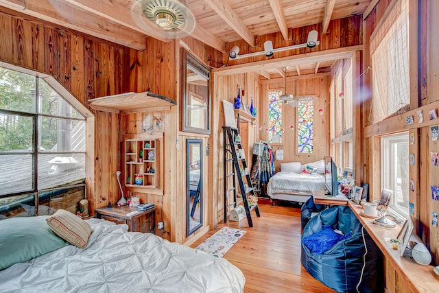 bedroom with wood ceiling, wooden walls, and beam ceiling