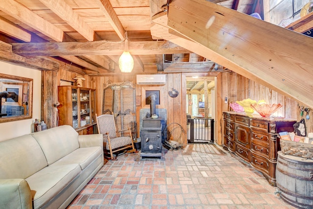 living room with wooden walls, a wall mounted AC, beam ceiling, and a wood stove