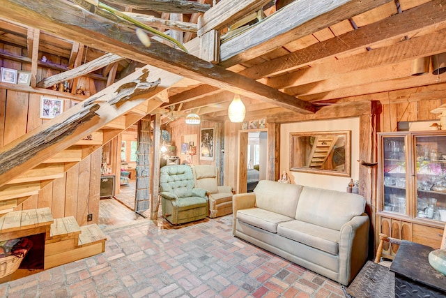 living room featuring beamed ceiling and wood walls