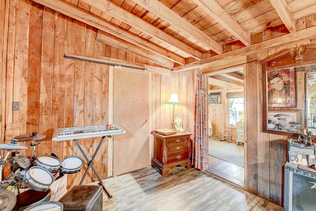 misc room featuring beam ceiling, hardwood / wood-style floors, wooden ceiling, and wooden walls