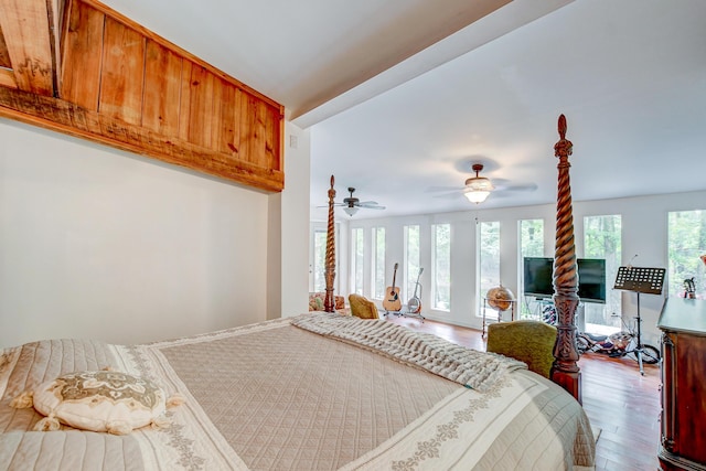 bedroom featuring multiple windows, hardwood / wood-style floors, and ceiling fan