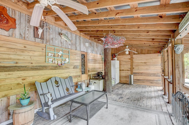 unfurnished room with lofted ceiling and wood walls