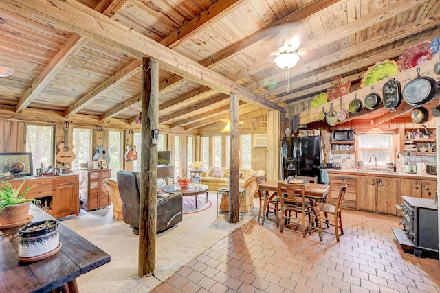 dining area with sink, wooden walls, wooden ceiling, and beam ceiling