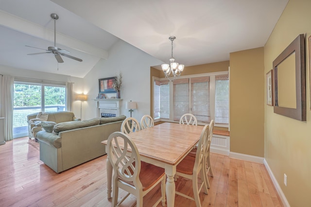 dining area with lofted ceiling with beams, ceiling fan with notable chandelier, and light hardwood / wood-style flooring