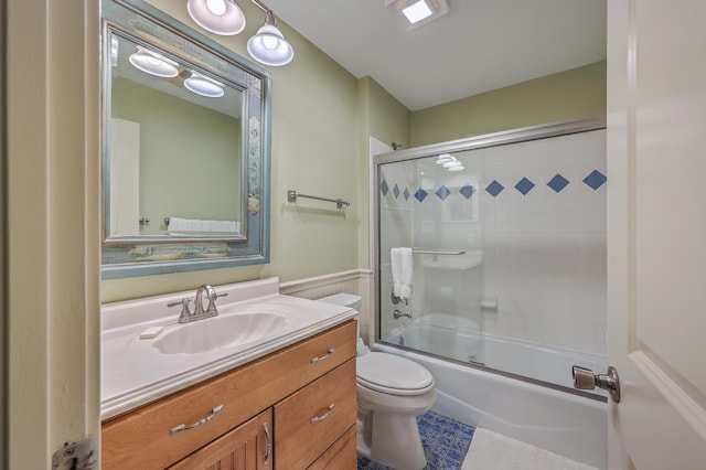 full bathroom featuring bath / shower combo with glass door, toilet, and vanity