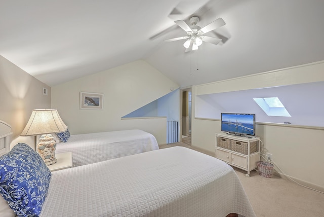 bedroom with light carpet, vaulted ceiling with skylight, and ceiling fan