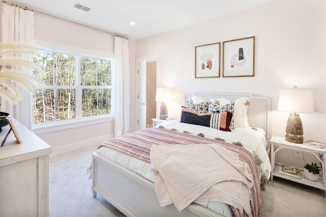 bedroom featuring baseboards, visible vents, and light colored carpet