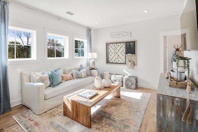 living area featuring light wood-type flooring, visible vents, and recessed lighting