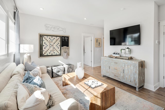 living area with baseboards, light wood-style flooring, and recessed lighting