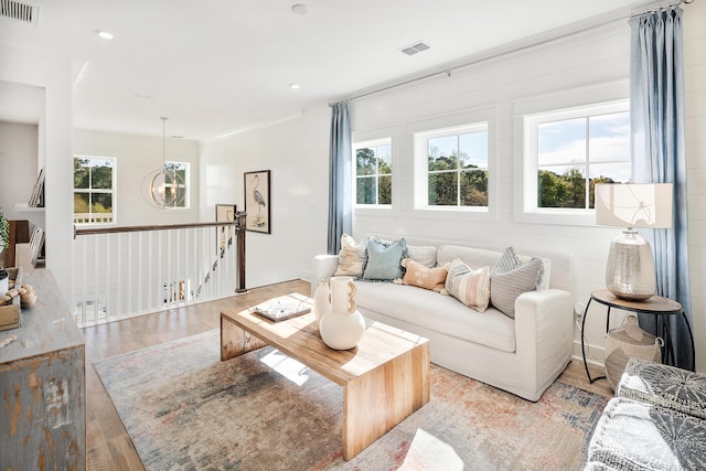 living room featuring plenty of natural light, visible vents, and light wood-style flooring