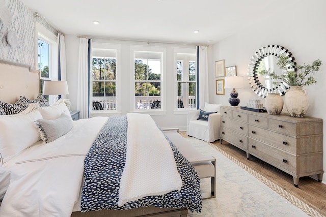 bedroom with light wood-style floors and recessed lighting