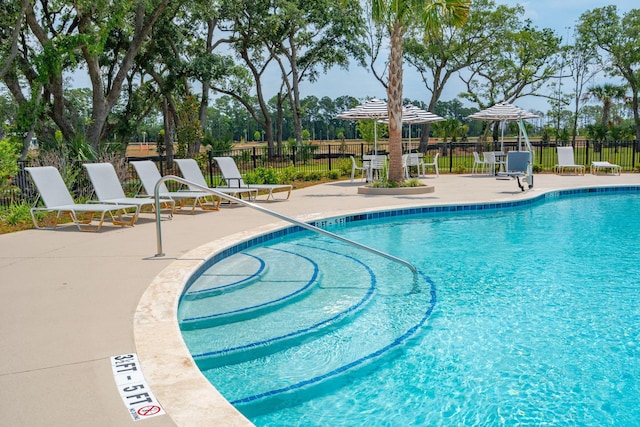 pool featuring fence and a patio