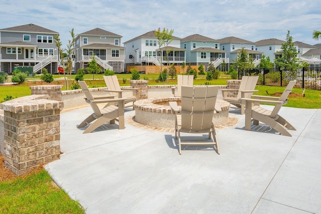 view of patio with an outdoor fire pit, stairs, a residential view, and fence