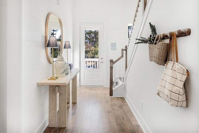 doorway with light wood-style floors and stairway