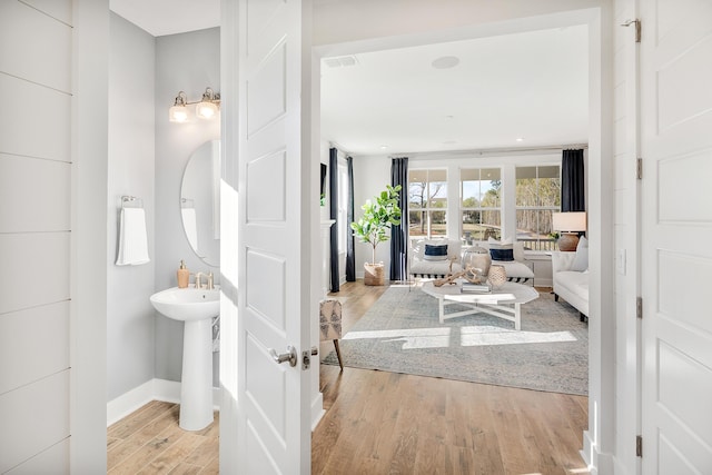 bathroom featuring a sink, baseboards, and wood finished floors