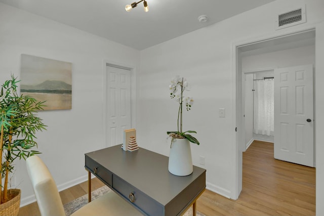 office space featuring visible vents, baseboards, and light wood-style flooring