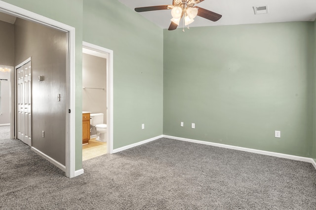 unfurnished bedroom featuring vaulted ceiling, connected bathroom, carpet, ceiling fan, and a closet