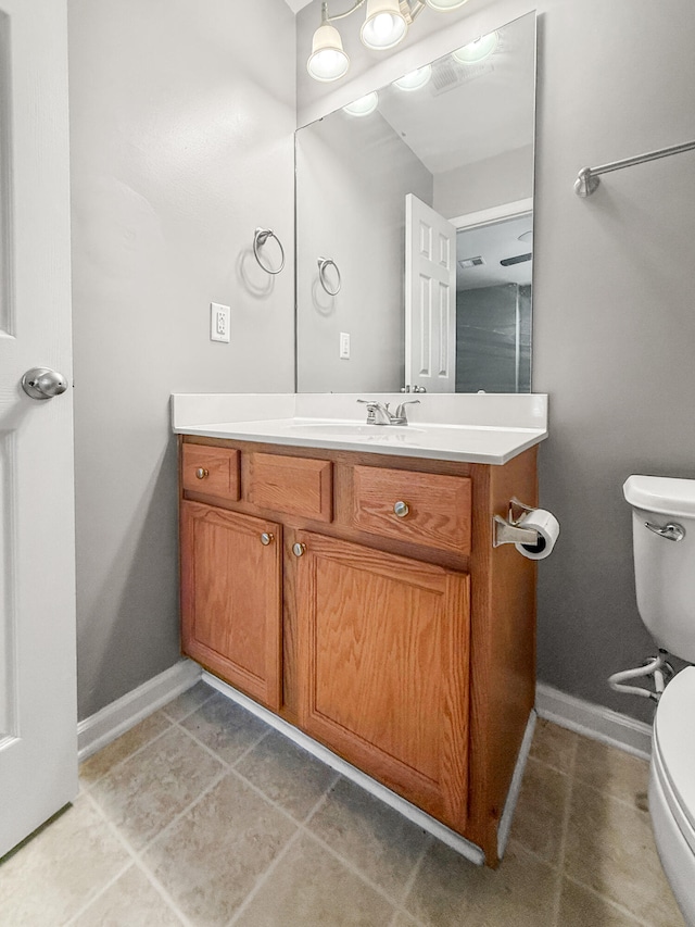 bathroom featuring vanity, tile patterned flooring, and toilet