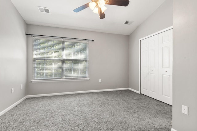 unfurnished bedroom featuring ceiling fan, carpet flooring, a closet, and vaulted ceiling