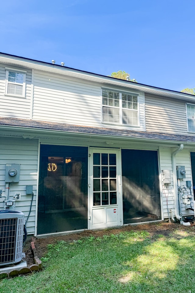 exterior space with central AC unit and a yard