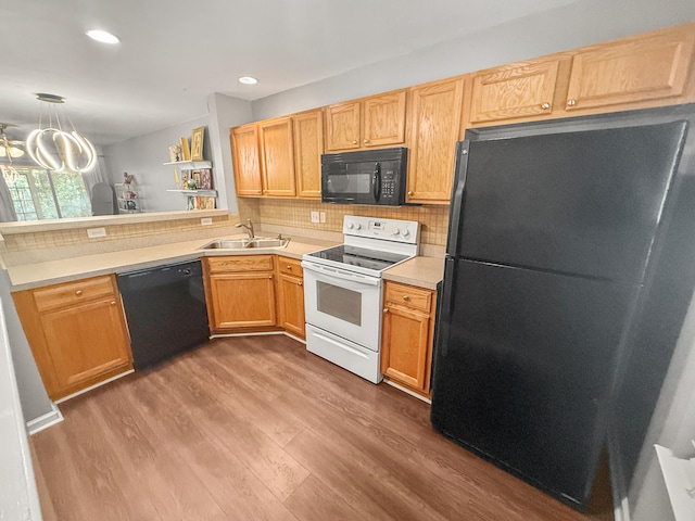 kitchen featuring sink, black appliances, kitchen peninsula, dark hardwood / wood-style floors, and decorative backsplash