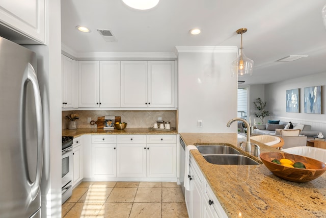 kitchen with stainless steel appliances, white cabinets, sink, light stone countertops, and pendant lighting