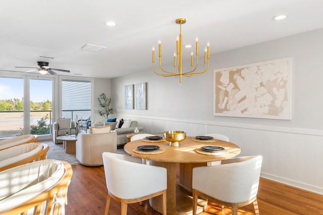 dining space featuring hardwood / wood-style flooring and ceiling fan with notable chandelier