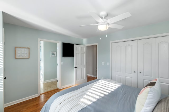 bedroom featuring dark hardwood / wood-style flooring, ceiling fan, and a closet