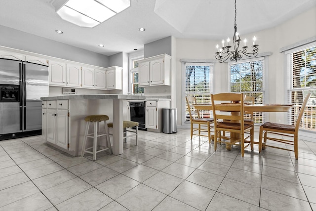 kitchen with white cabinetry, stainless steel fridge, a wealth of natural light, and a kitchen island