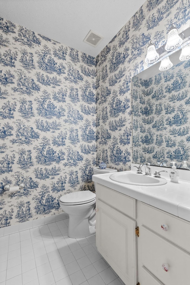 bathroom with vanity, visible vents, wallpapered walls, tile patterned floors, and toilet