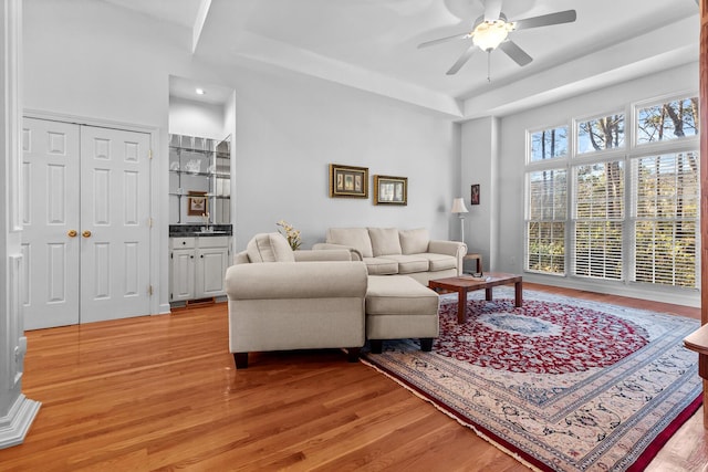 living area with light wood-type flooring and ceiling fan