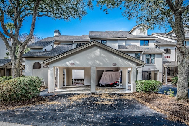 multi unit property featuring a carport and stucco siding