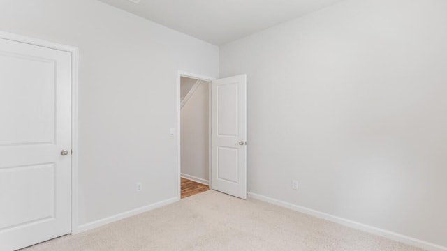 spare room featuring light colored carpet