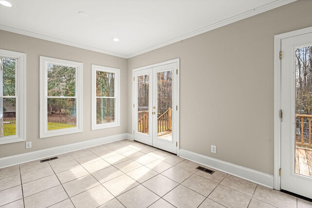 tiled empty room with plenty of natural light, french doors, and ornamental molding