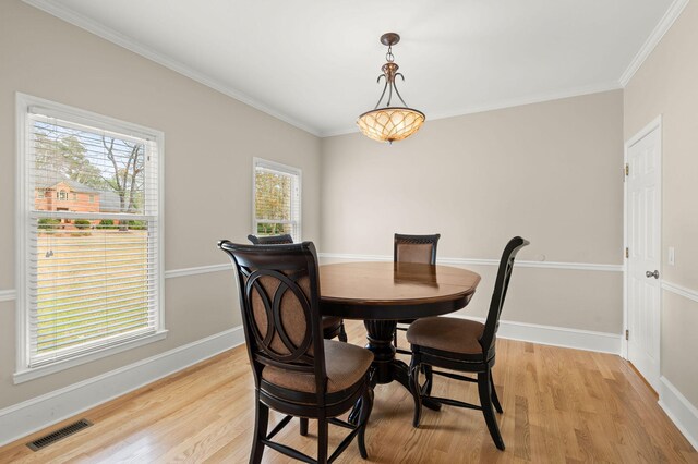 dining area featuring light hardwood / wood-style flooring and crown molding