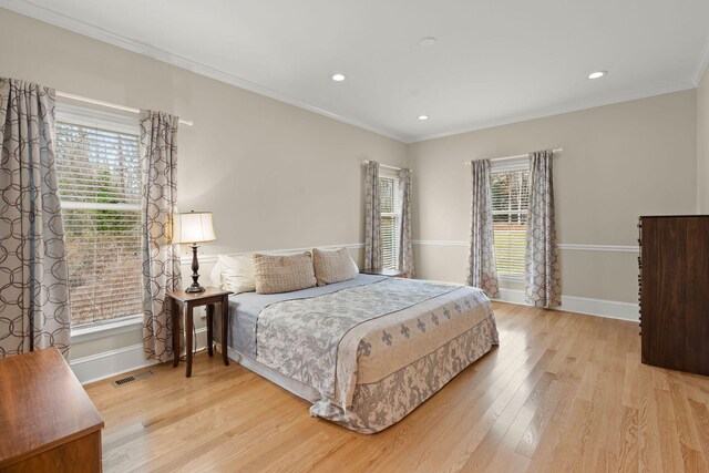 bedroom with light hardwood / wood-style floors and crown molding