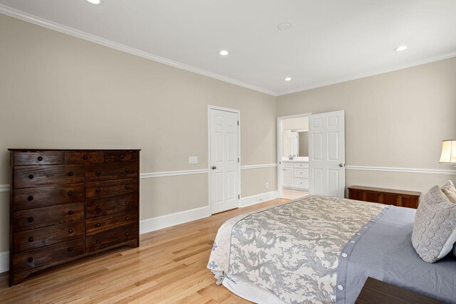 bedroom with light hardwood / wood-style flooring, crown molding, and ensuite bathroom