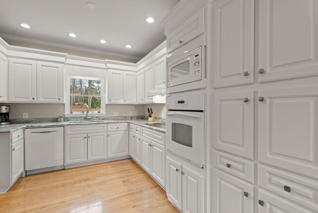 kitchen featuring sink, white cabinetry, white dishwasher, and light wood-type flooring