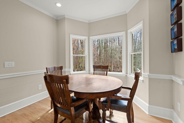 dining room featuring a wealth of natural light, light hardwood / wood-style floors, and crown molding