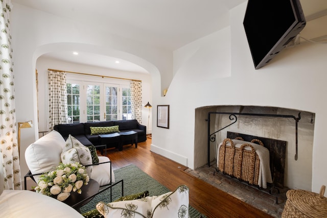 living room with dark wood-type flooring and a fireplace