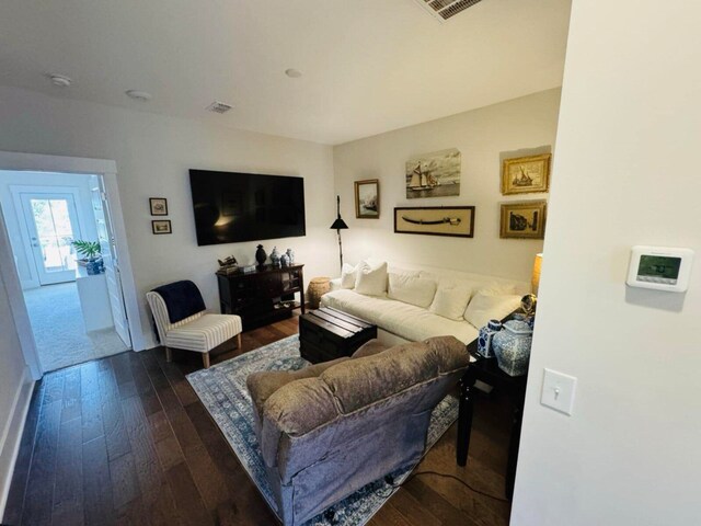 living area with visible vents and dark wood-style floors