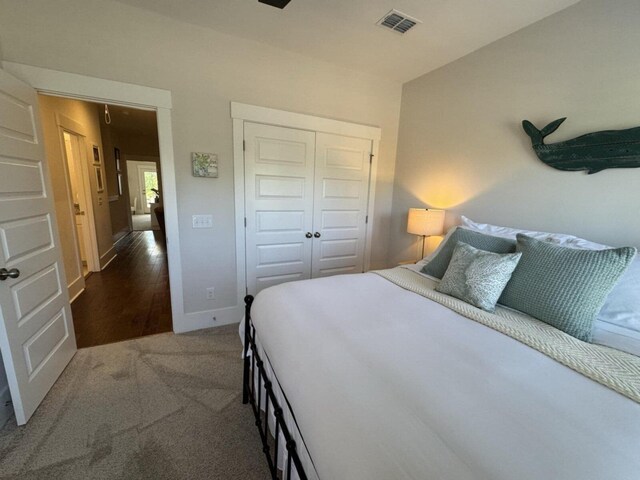 bedroom featuring carpet, visible vents, a closet, and baseboards