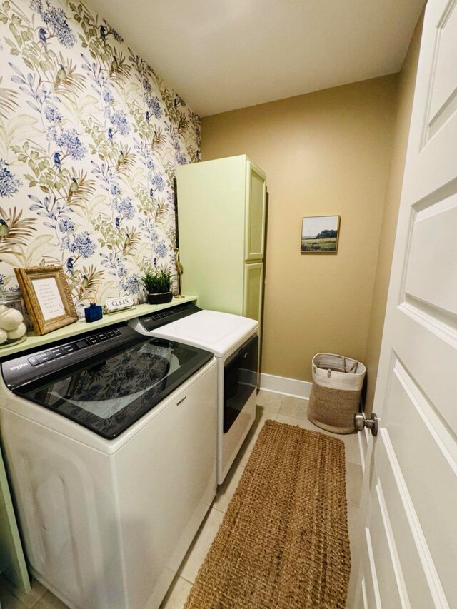 kitchen with baseboards, washing machine and dryer, light tile patterned flooring, and wallpapered walls