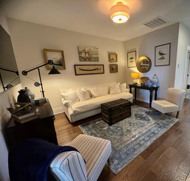 living area with visible vents, baseboards, and wood finished floors