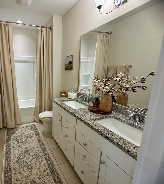 bathroom with tile patterned floors, shower / bath combination with curtain, toilet, and a sink