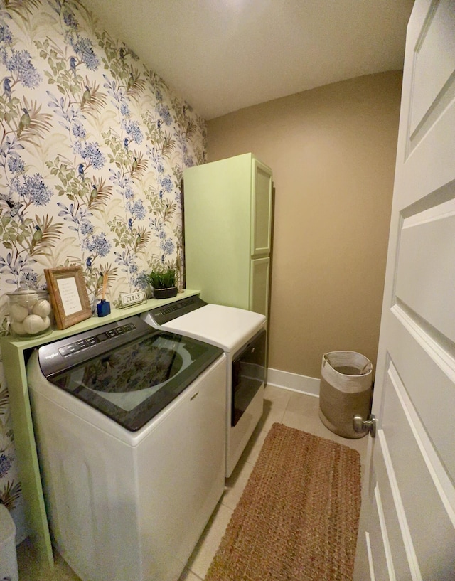 laundry room with baseboards, wallpapered walls, light tile patterned flooring, cabinet space, and washer and dryer