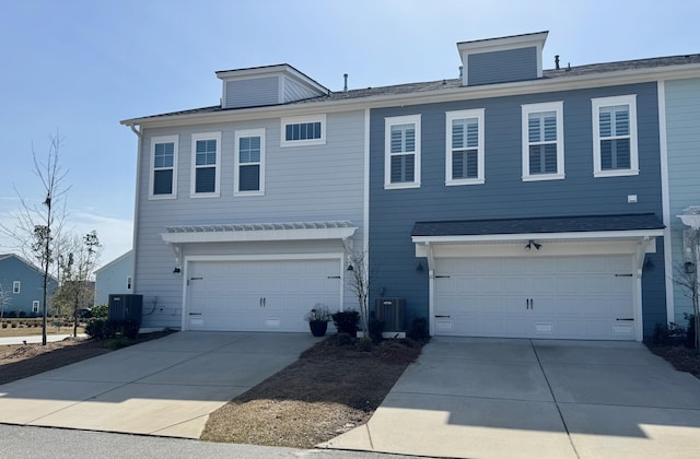 view of front of house with a garage, central AC, and driveway