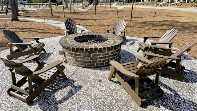 view of property's community with a patio area, a playground, and an outdoor fire pit