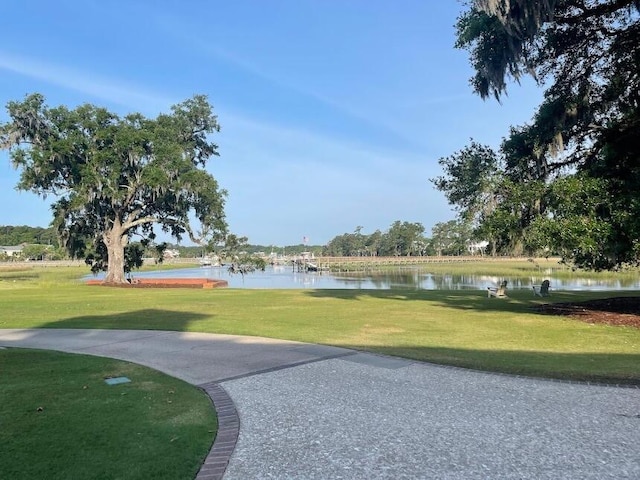 view of property's community with a yard and a water view