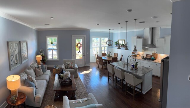 living area featuring baseboards, visible vents, dark wood-style flooring, and ornamental molding